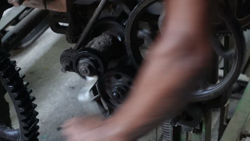 Technician repairing industrial power loom machine	