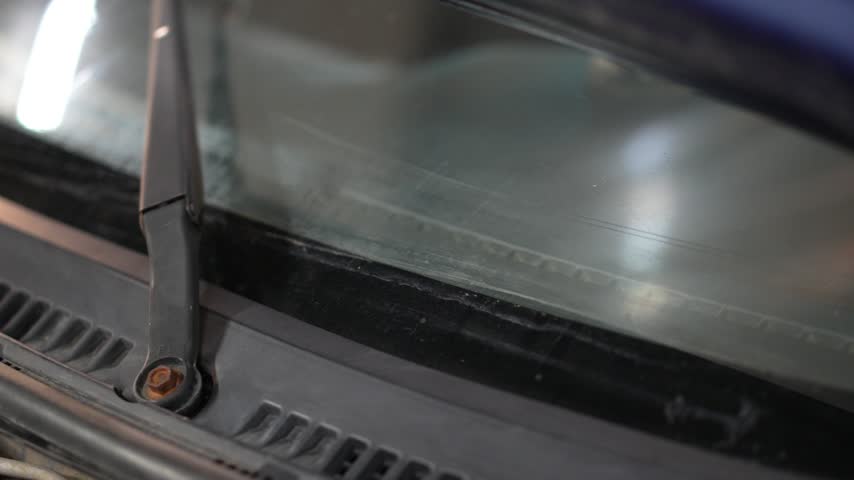 Car Windshield Wiper Arm with Mounting Nut, This video clip shows a close-up of a car windshield wiper arm with mounting nut on a reflective surface