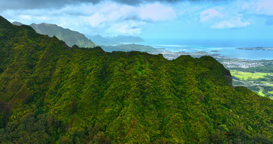 Rising above the rugged verdant mountain range. Revealing view spectacular Honolulu cityscape at the backdrop of azure waterscape.