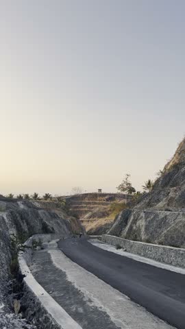 Cyclist Riding on a Mountain Road at Sunset