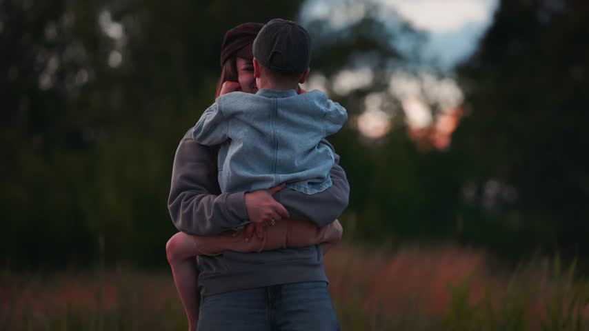 Brothers at river shore share a warm embrace, surrounded by lush greenery and tall grass, capturing a heartfelt moment in nature