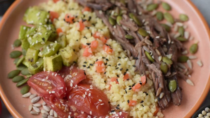 A bowl with beef, porridge, mushrooms, vegetables, sauce, and spices. Beef bowl