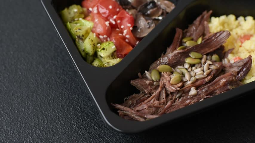 A bowl with beef, porridge, mushrooms, vegetables, sauce, and spices. Beef bowl
