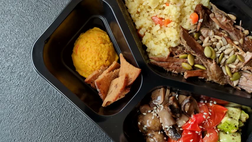 A bowl with beef, porridge, mushrooms, vegetables, sauce, and spices. Beef bowl