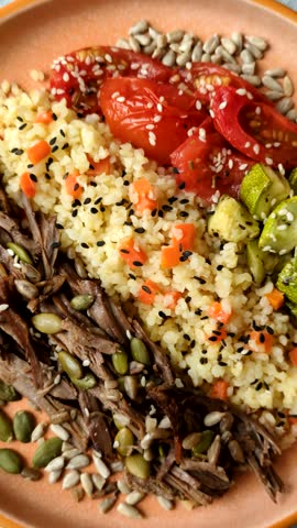A bowl with beef, porridge, mushrooms, vegetables, sauce, and spices. Beef bowl