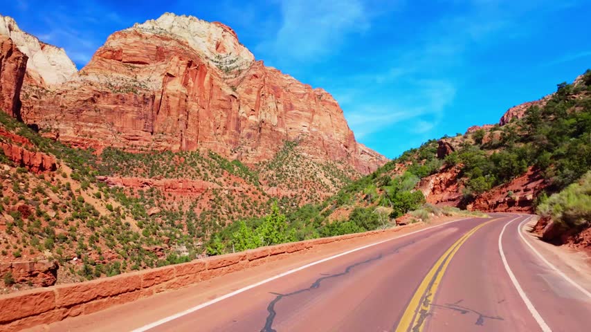Scenic winding road curves through the panoramic rock rim formations of Zion National Park