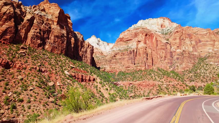 Scenic winding road curves through the panoramic rock rim formations of Zion National Park