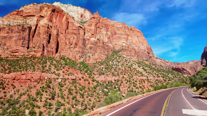 Scenic winding road curves through the panoramic rock rim formations of Zion National Park