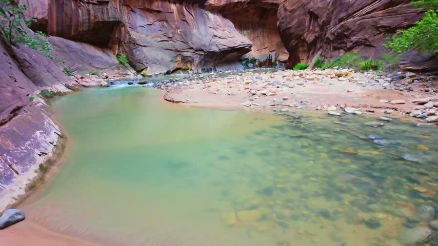 Virgin River flows scenically through the iconic Narrows trail canyon in Zion National Park