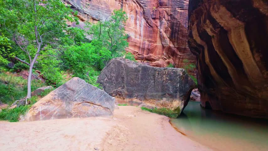 Golden sunrise light glows through the iconic Narrows trail along the Virgin River in Zion National Park