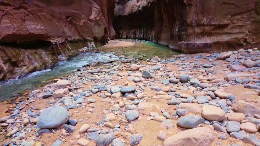 Golden sunrise light glows through the iconic Narrows trail along the Virgin River in Zion National Park