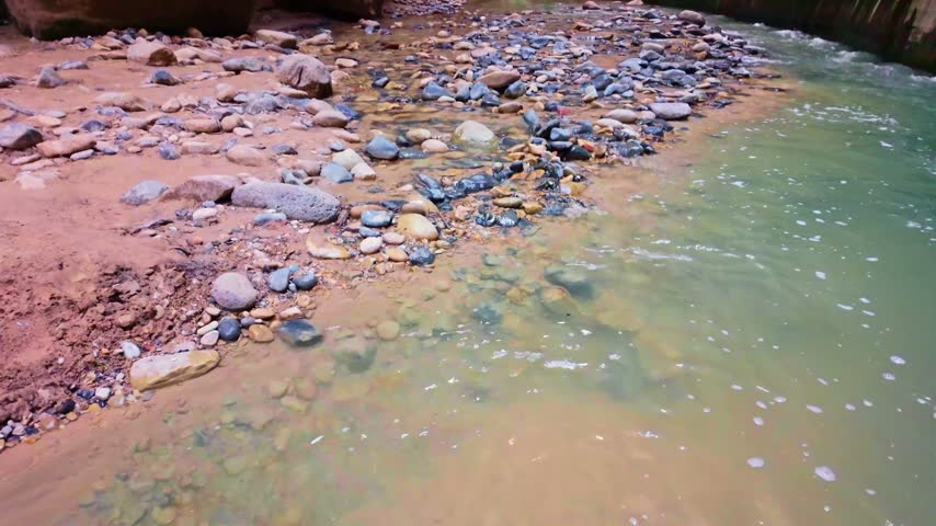 Virgin River flows scenically through the iconic Narrows trail canyon in Zion National Park