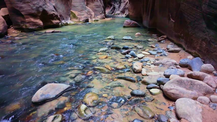 Virgin River flows scenically through the iconic Narrows trail canyon in Zion National Park