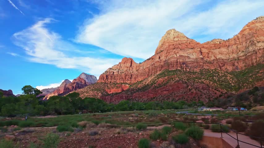 Golden sunset light glows over the mountains as seen from the top of the Watchman Trail in Zion National Park