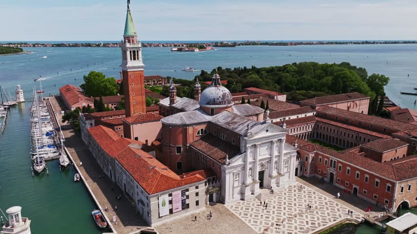 Aerial drone view of San Giorgio Maggiore Church in Venice, Italy, showcasing its iconic Renaissance architecture, grand dome, bell tower, island setting, and panoramic Venetian lagoon.