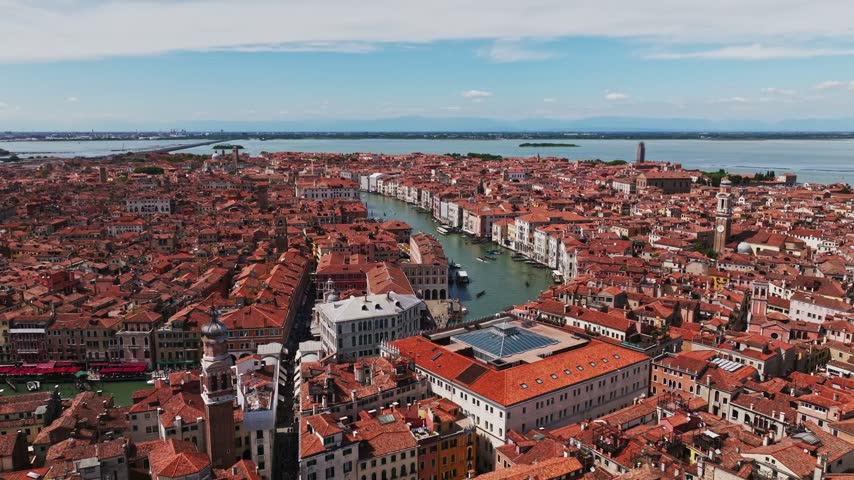Aerial drone view of Venice, Italy, showcasing the iconic Venetian canals, historic architecture, dense cityscape, waterways, rooftops, and picturesque islands of the Venetian Lagoon.