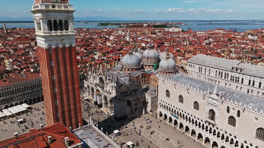 Aerial drone view of Saint Mark’s Basilica in Venice, Italy, showcasing its iconic domes, Byzantine architecture, ornate façade, and historic surroundings in the heart of Venice.