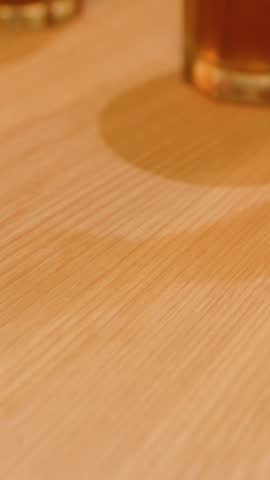 Close-up of hands thoroughly cleaning a wooden dining table using tissue paper in Bangkok, Thailand.