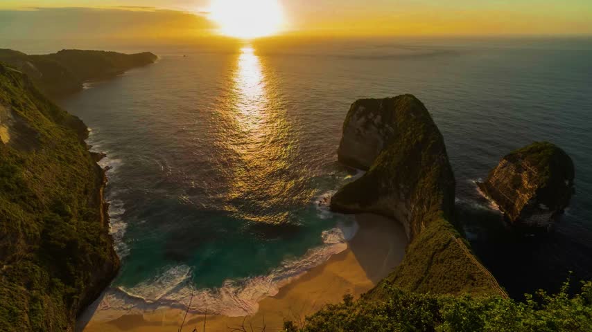 A time-lapse view captures a scenic coastal landscape featuring a rocky foreground with a calm tide pool, waves breaking in the distance, and a soft, cloudy sunset sky. The expansive composition surveys coastal water motion, cloud drift overhead, and dark shoreline elements during the evening transition. This coastal landscape asset suits travel documentaries, relaxation videos, meteorological time-lapse sequences, and cinematic establishing shots requiring peaceful marine settings.   