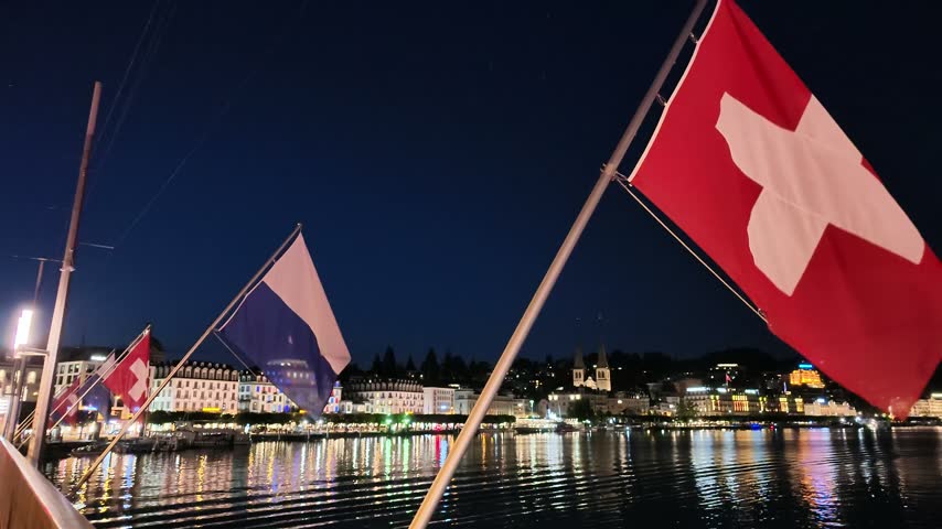 Swiss flags waving over the famous Seebrücke Lake Bridge in Lucerne, Switzerland.
