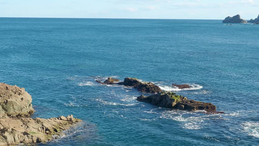 Waves crashing against a rocky shoreline along the Sanriku Coast in Taro, Miyako City, Iwate Prefecture, Japan, with the Pacific Ocean stretching toward the horizon.