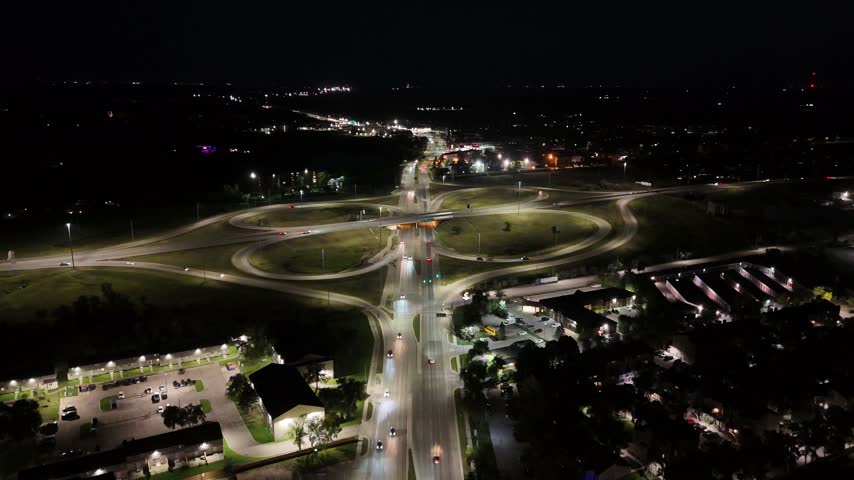 Static night drone aerial over the South Perimeter Highway and Pembina Highway interchange showing car lights, buildings, and traffic in South Winnipeg, Manitoba, Canada.