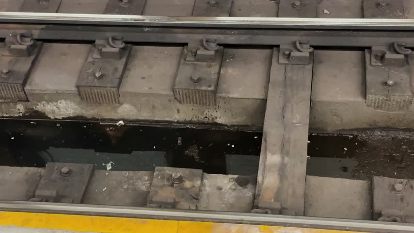 Close-up of subway tracks and platform edge in an underground transit station