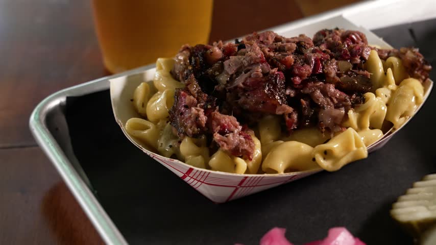 Creamy hatch macaroni and cheese topped with smoky chopped barbecue brisket, close up, slider, 4K
