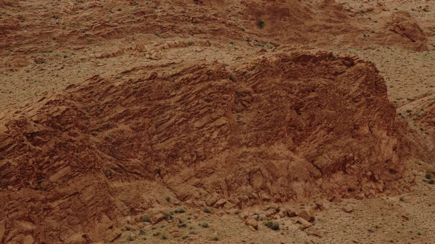 Red rock formations in the desert landscape of Morocco. Majestic mountains and cliffs create a dramatic scenery. Perfect for travel, nature, or adventure documentaries.