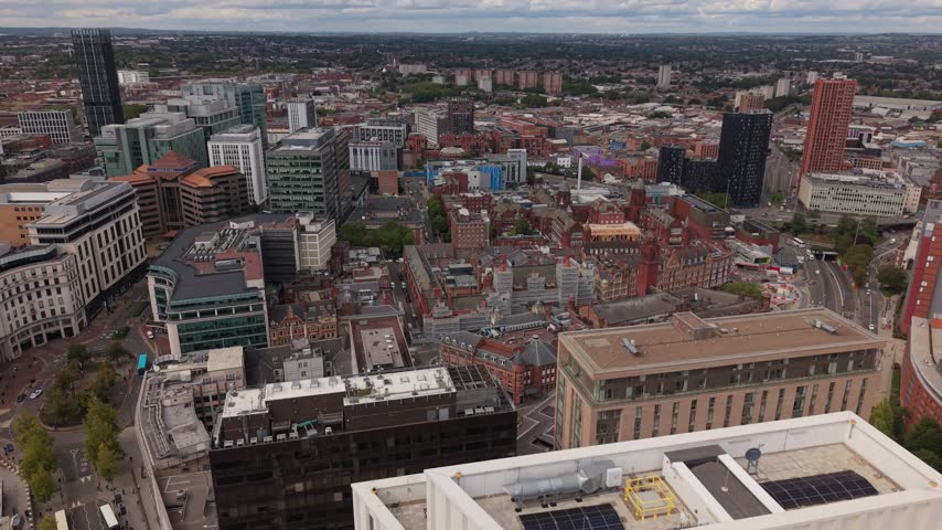 Aerial view over Birmingham city centre showing the contrast between historic red brick architecture and modern high-rise buildings, illustrating urban transformation and development in England.