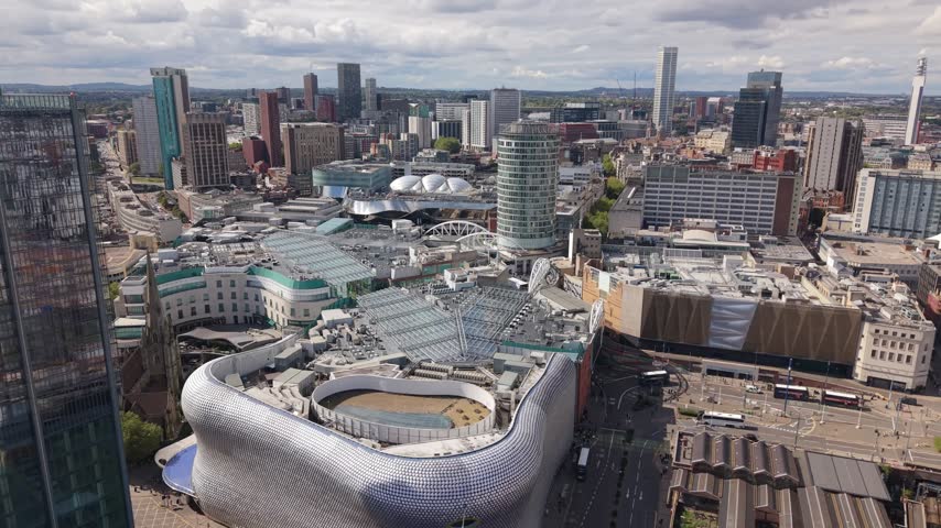 Aerial view over Birmingham city centre in England, revealing a dense mix of modern high-rise buildings, distinctive architecture, commercial complexes and the expanding urban skyline.