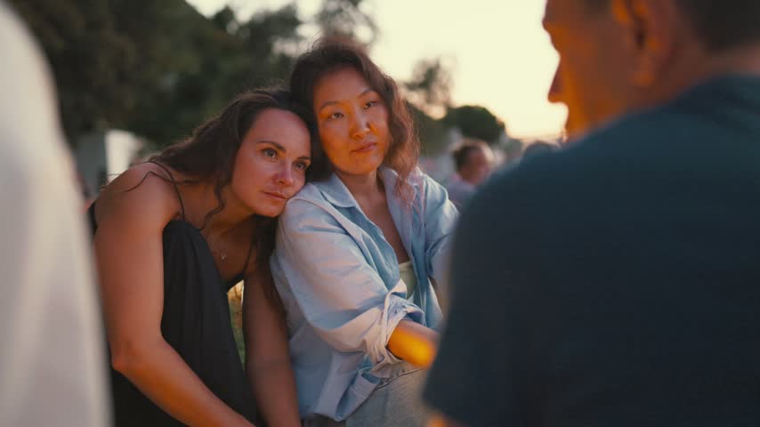 Friends share moments during sunset at a park gathering