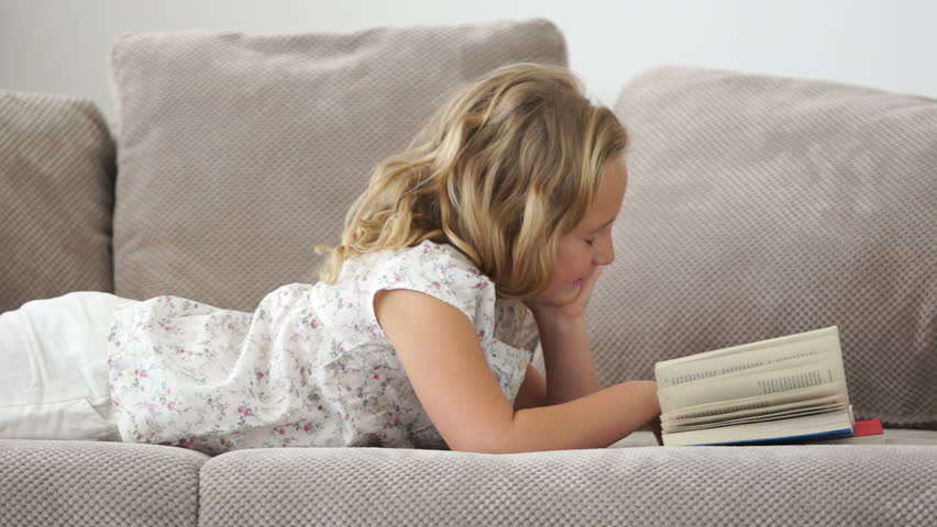 Girl lying on the couch and read a good book
