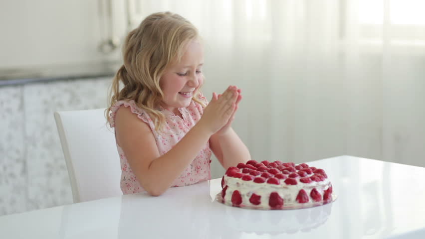 Sweet little girl getting ready to eat a strawberry cake
