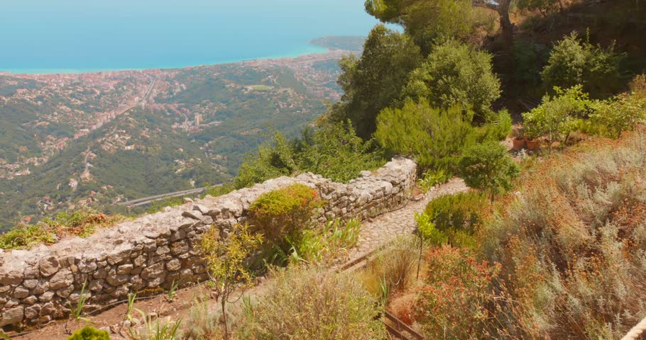 Stone garden path overlooking Mediterranean coastline and hills in Sainte-Agnes, France