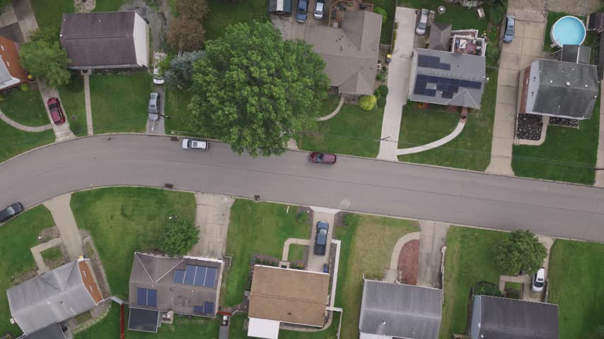 Drone aerial above homes, houses, and suburb in north side hills of Pittsburgh, PA in Perry North Observatory and Summer Hill with cars, streets, trees, and hilly landscape of western Pennsylvania 4k