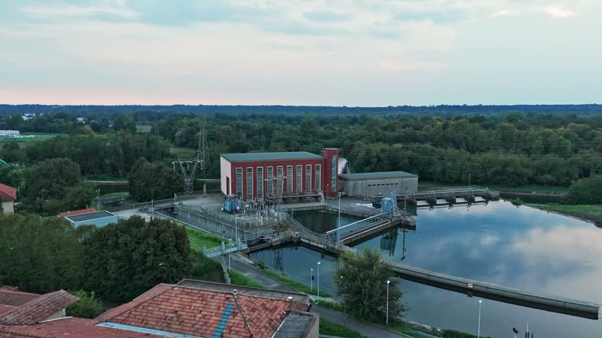 Aerial view of a hydroelectric power station on a river. Industrial plant generating clean, renewable energy with water and turbines