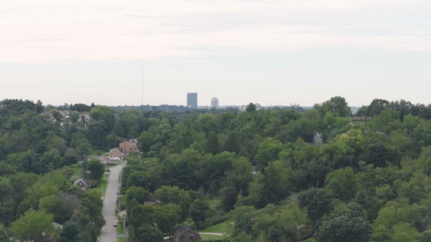 Drone aerial above homes, houses, and suburb in north side hills of Pittsburgh, PA in Perry North Observatory and Summer Hill with cars, streets, trees, and hilly landscape of western Pennsylvania 4k