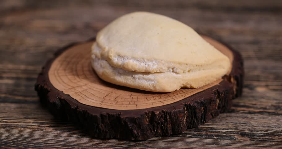 sliced fresh shortbread bun with juicy curd filling on a wooden board on the table, soft pastries stuffed with cottage cheese and sugar lie on the board after being cut