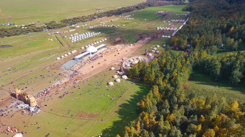 Aerial view of festival stadium, main stage, and rapid yurt assembly competition at World Nomad Games 2026 in Kyrchyn Gorge, Kyrgyzstan
