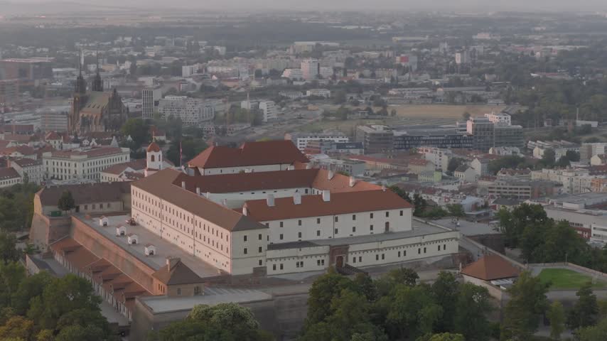 Špilberk Castle sits above central Brno as the camera flies past, revealing the historic fortress framed by the surrounding city.