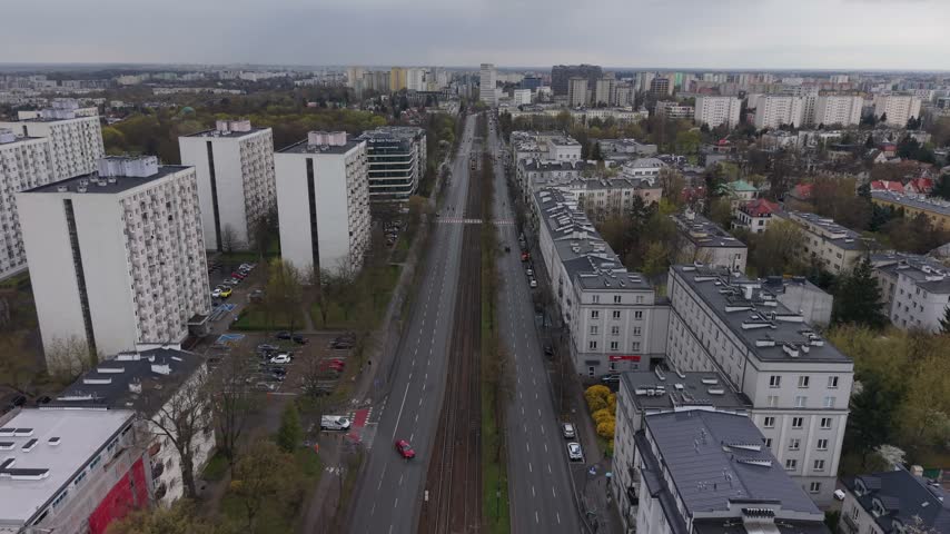Aerial view of street in Warsaw with residential blocks and tram tracks under a cloudy sky