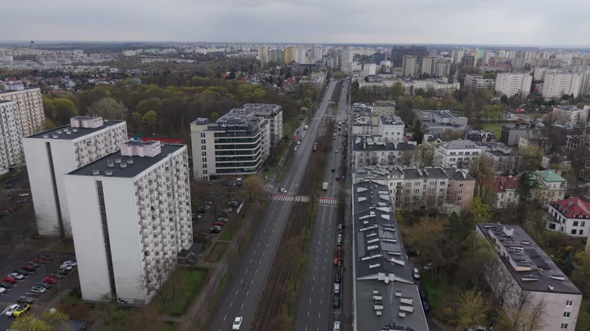 Aerial view of street in Warsaw with residential blocks and tram tracks under a cloudy sky