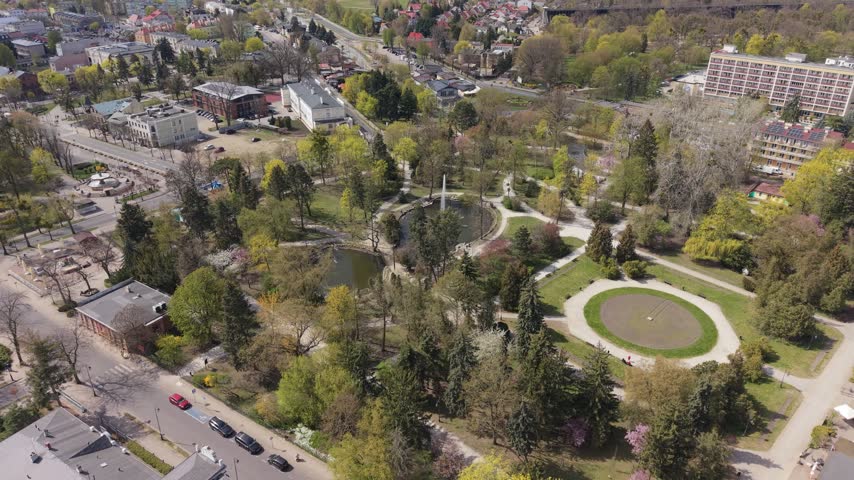Wide aerial view of the lush Zdrojowy Park with its fountain and walking paths in Ciechocinek, Poland