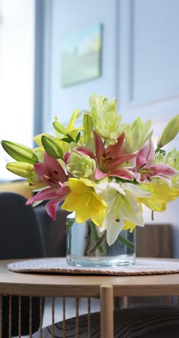 Bouquet of beautiful lilies in vase on table indoors
