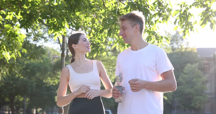 Happy sporty couple talking before run in park