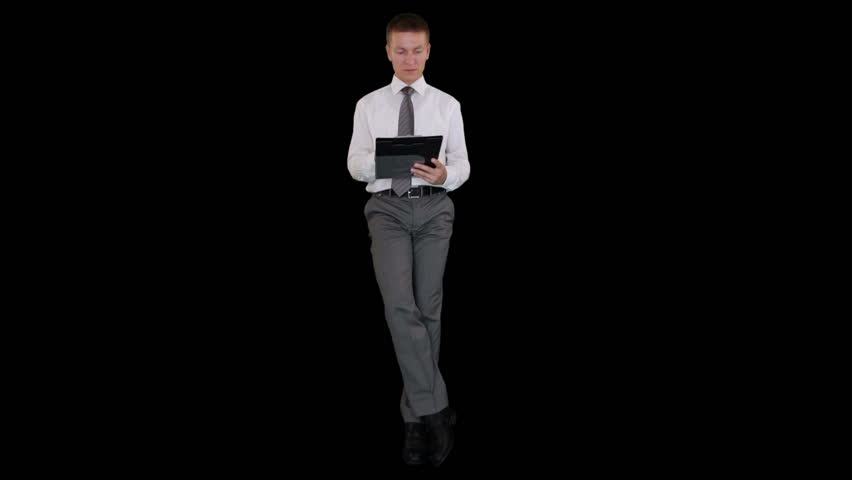 Young businessman writting on a clipboard and sitting, against black