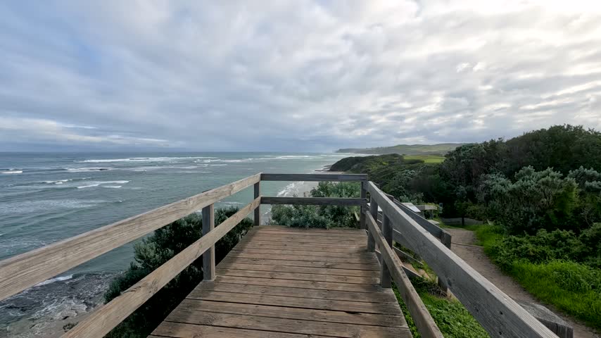 Forward moving view across a wooden coastal viewing platform overlooking ocean waves in Flinders, Australia.