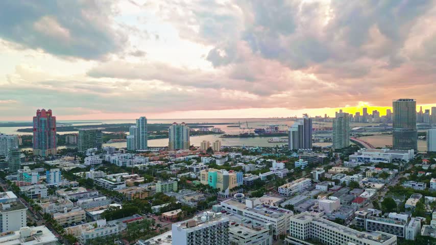 Miami beach city sunset panorama. Miami aerial bay shoreline. Miami skyline dusk clouds. Miami Florida ocean coast.