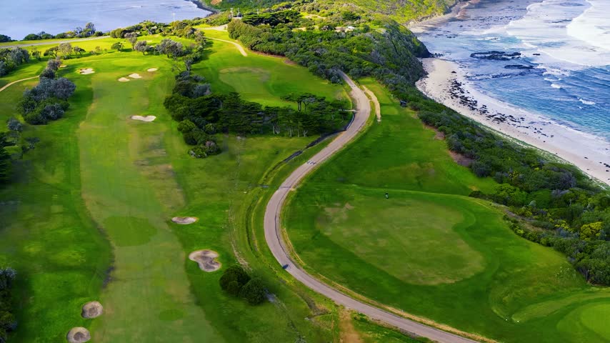 Aerial view over a lush green seaside golf course along coastal cliffs in Victoria, Australia.